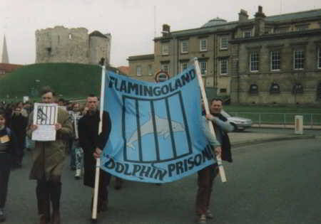 people holding banner - flamingoland dolphin prison
